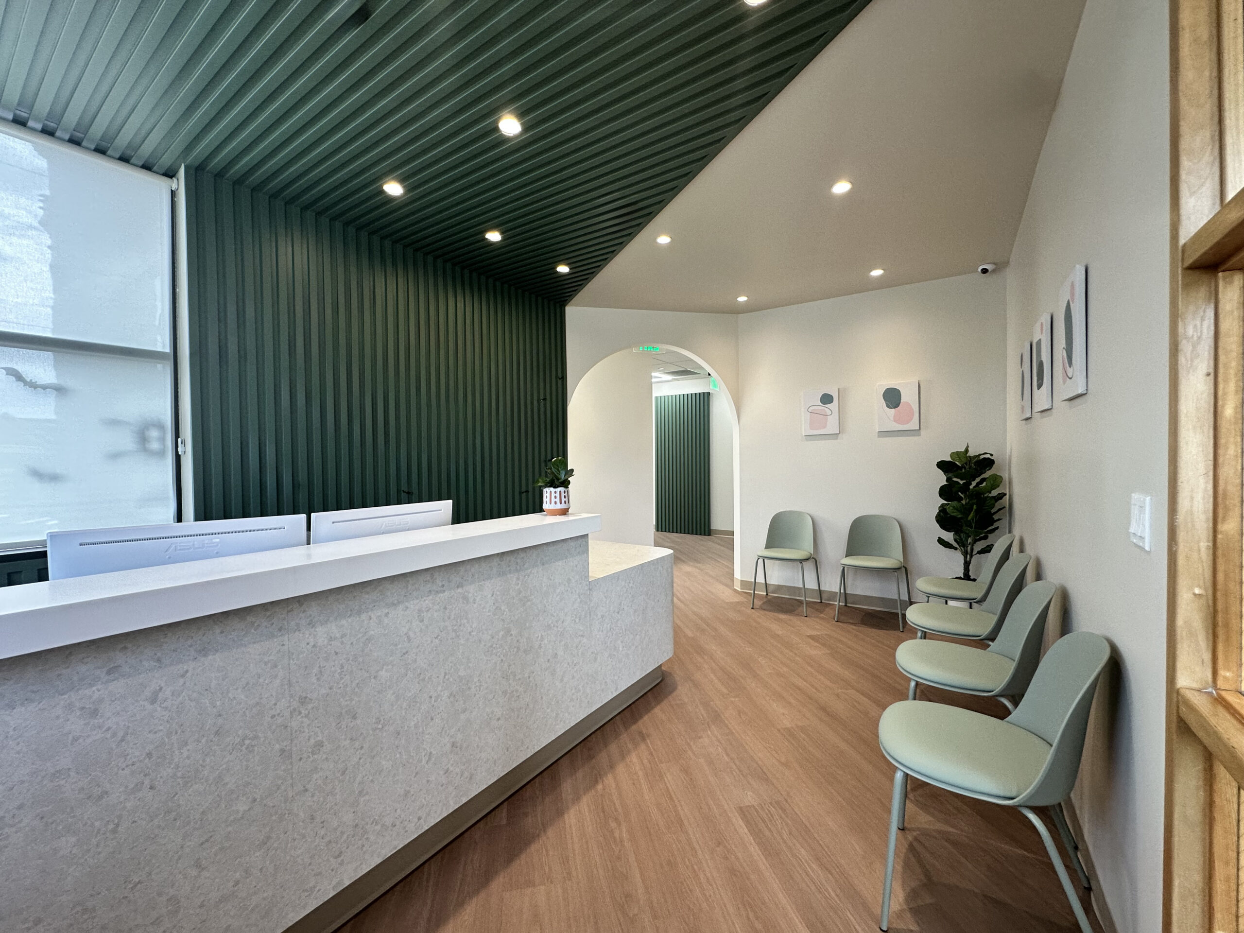 Modern orthodontic reception area with custom front desk and patient waiting space.